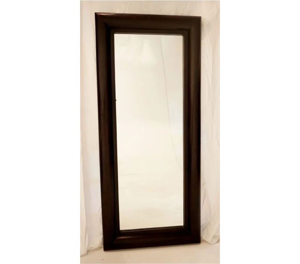 A mirror with a wooden frame on the wall.