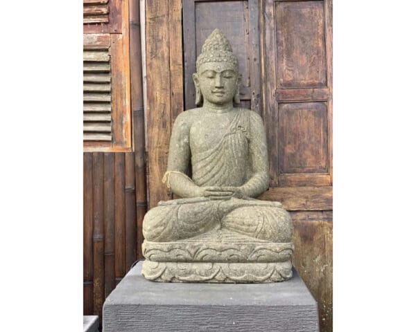 A statue of buddha sitting on top of a stone slab.