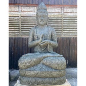 A statue of buddha sitting in the middle of a garden.