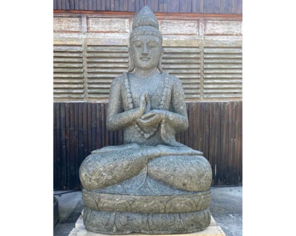 A statue of buddha sitting in the middle of a garden.