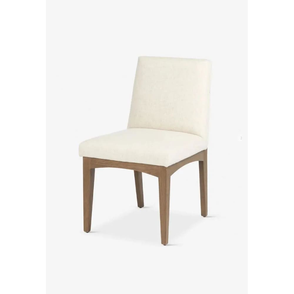 A white chair with wooden legs and a cushion.