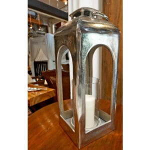 A silver lantern with candles inside of it.