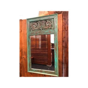 A mirror with an ornate frame on the side of a wooden wall.