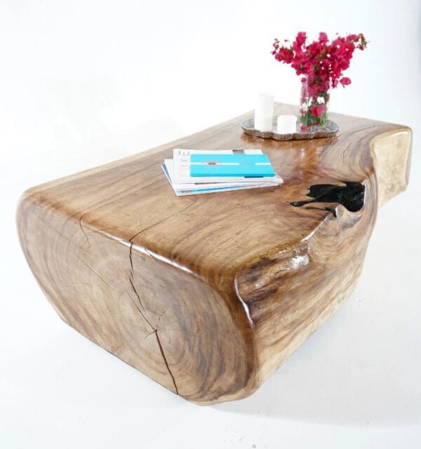 A wooden table with a vase of flowers on top.