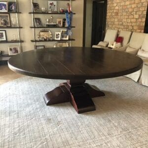 Dark wood round table with a pedestal base.