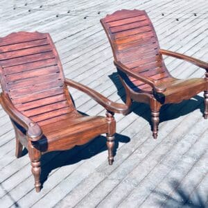 Two wooden chairs on a deck.