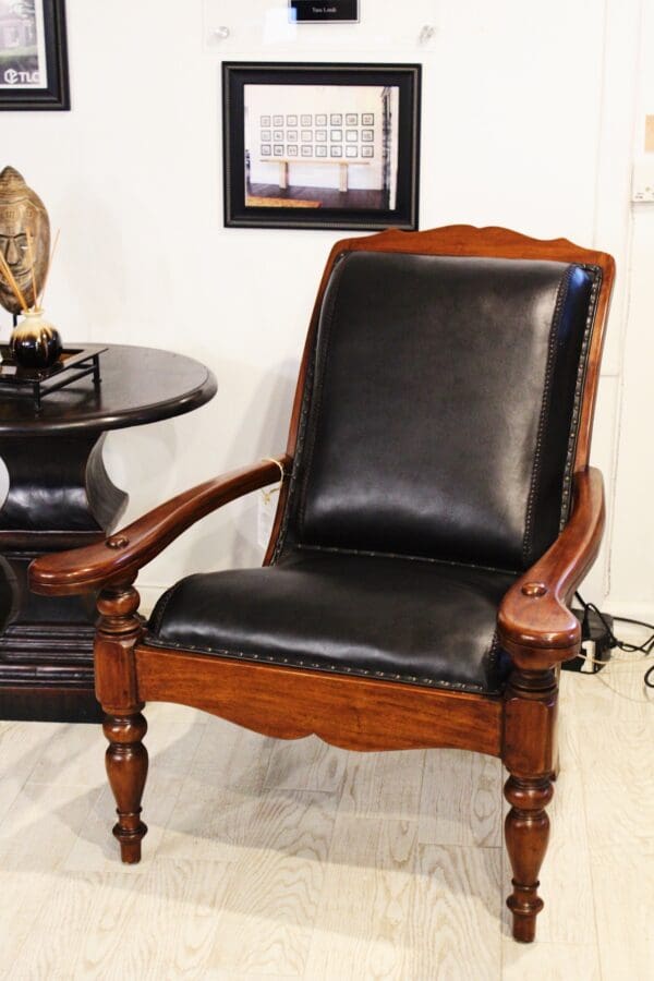 Black leather armchair with wooden legs.