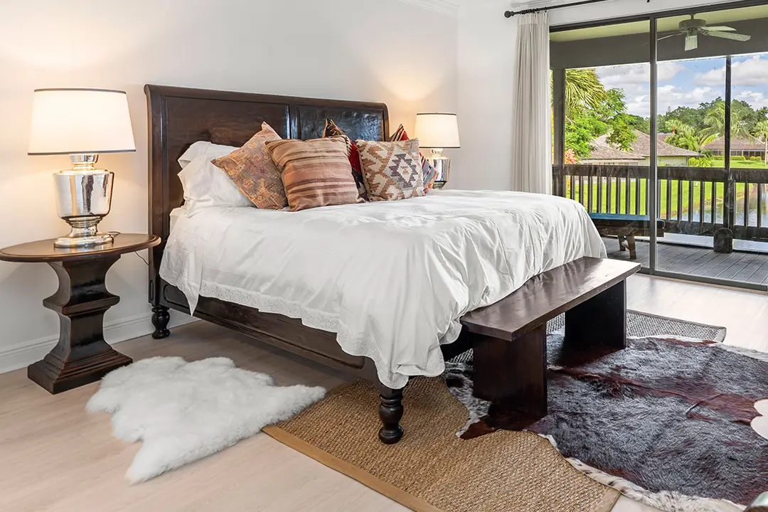White comforter, patterned pillows and balcony view